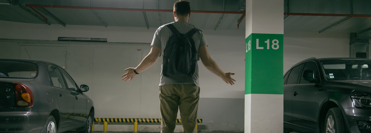 gestolen auto; man met armen op zij komt in de parkeergarage en zijn auto is weg